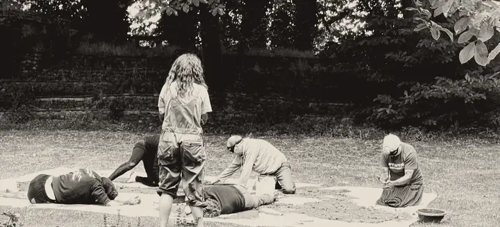 Séance en groupe : des participants aux yeux bandés travaillent la terre, Erika les accompagne